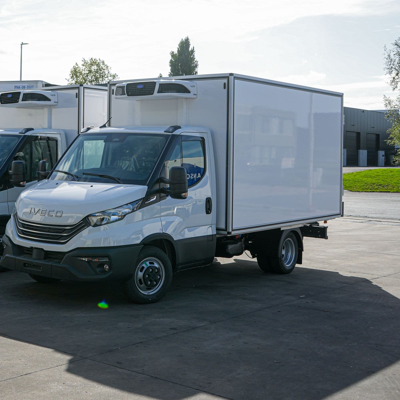 Two white Iveco Dailys with an Isocar box, seen from the front three-quarter