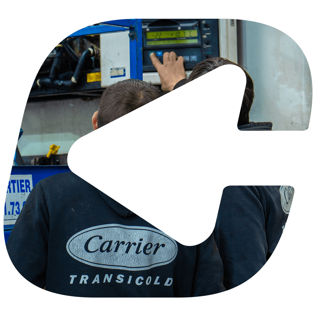 Two Carrier Transicold technicians at the control panel of a trailer refrigeration unit