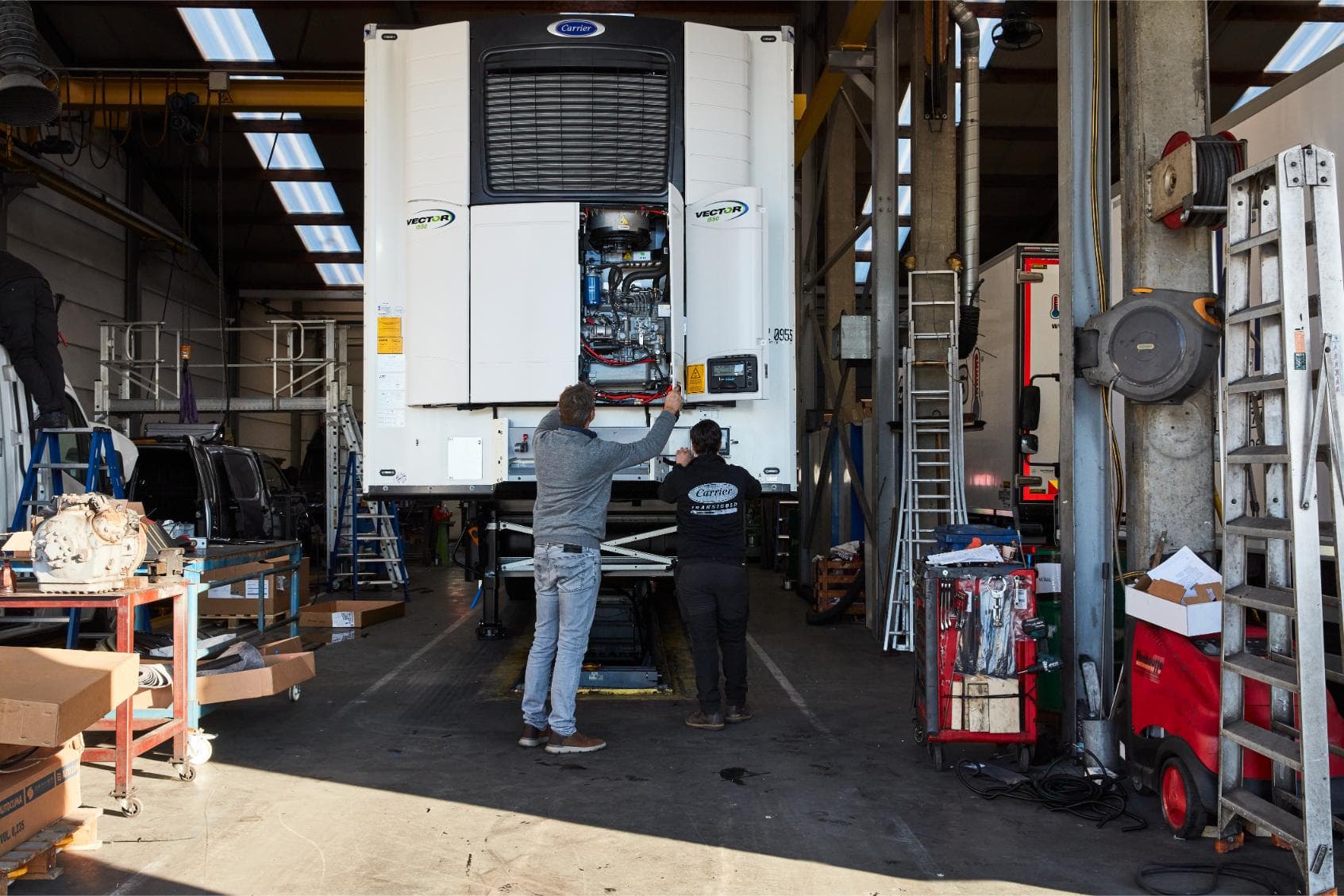 Two Westcool engineers at an opened Carrier Vector unit on a trailer in our own workshop